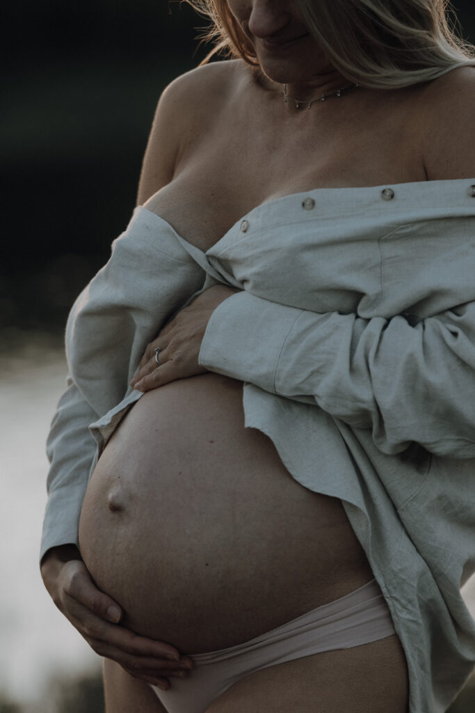 Babybauch im Detail draussen im Abendlicht fotografiert